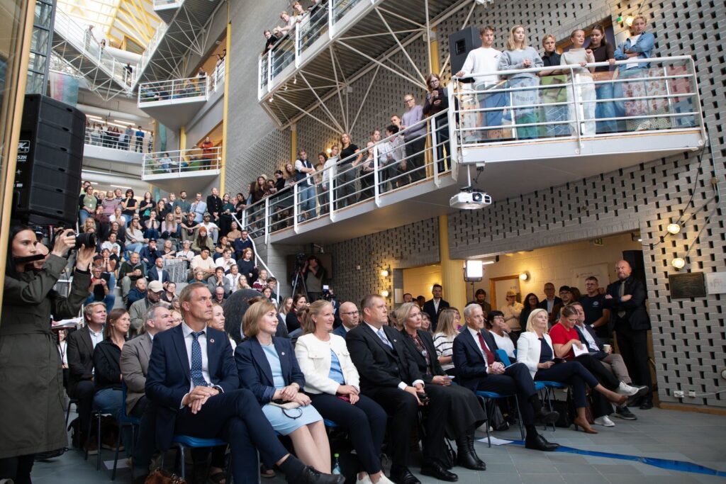 Bilde av mennesker som lytter til statsminister Jonas Gahr Støre under et besøk på Universitetet i Tromsø