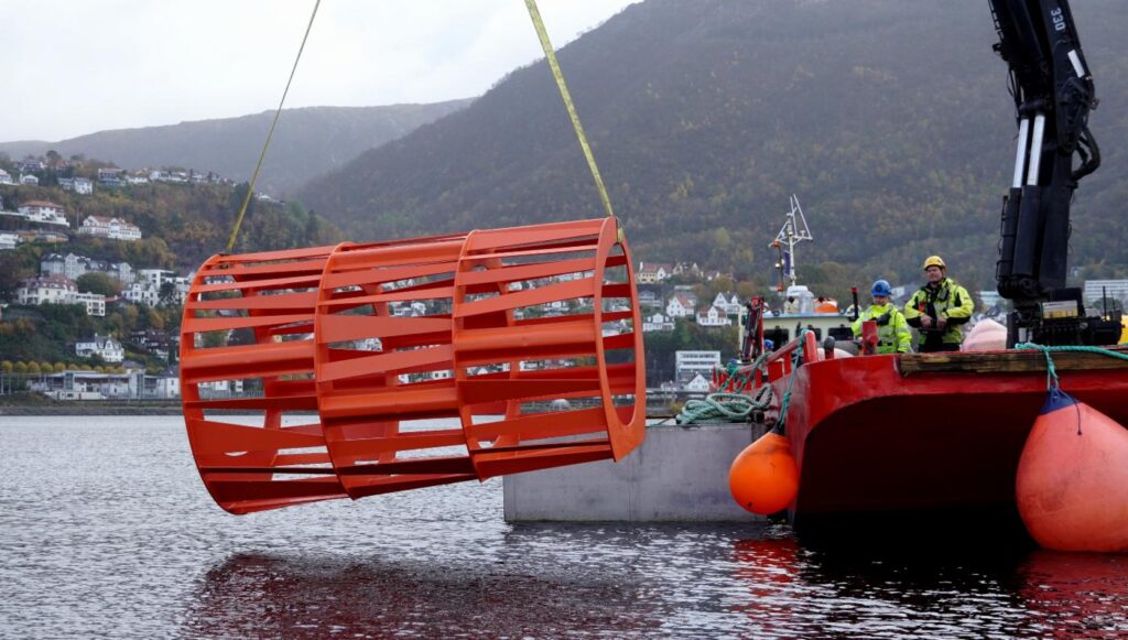 Et kunstig rev holdes over Store Lungegaardsvann med en kran.