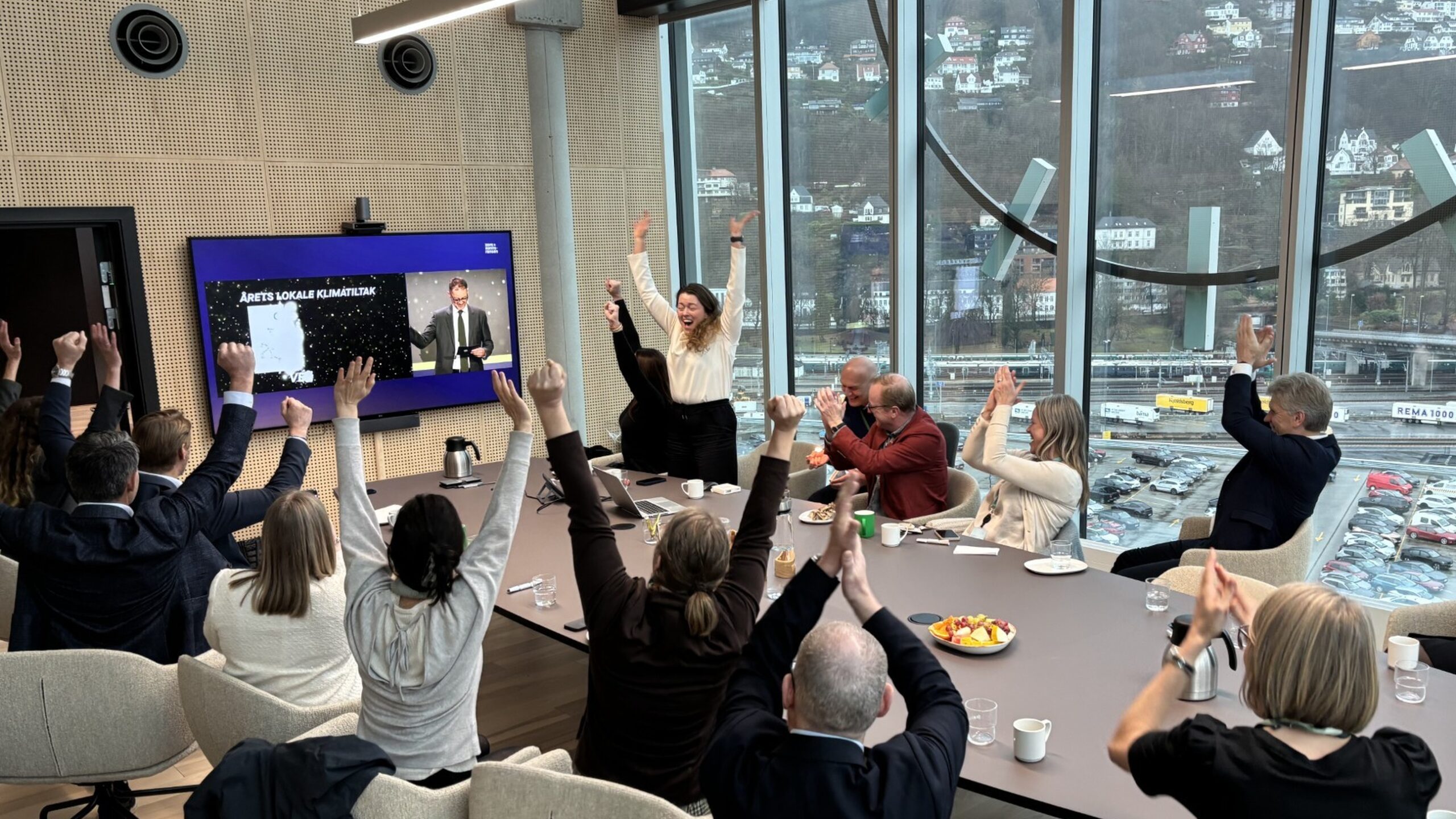 Mennesker rundt et bord jubler over prisdryss til Vestland